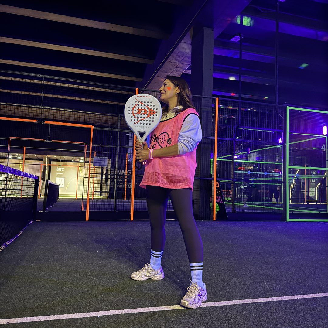 A player on court during a glow-lit evening session at Salus Padel.